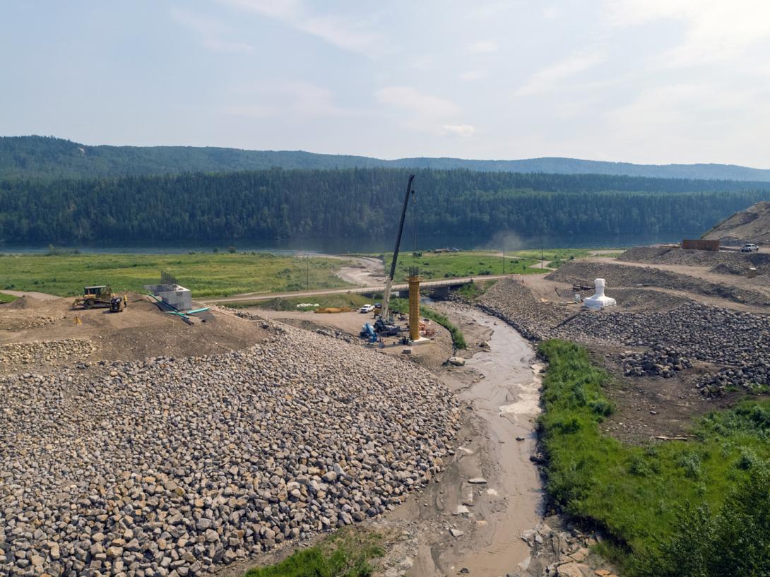 The Lynx Creek bridge alignment on Highway 29 showing the east abutment, bridge pier 2 formwork, pier 1 wrapped in plastic for concrete curing, and the west abutment under construction. | July 2021