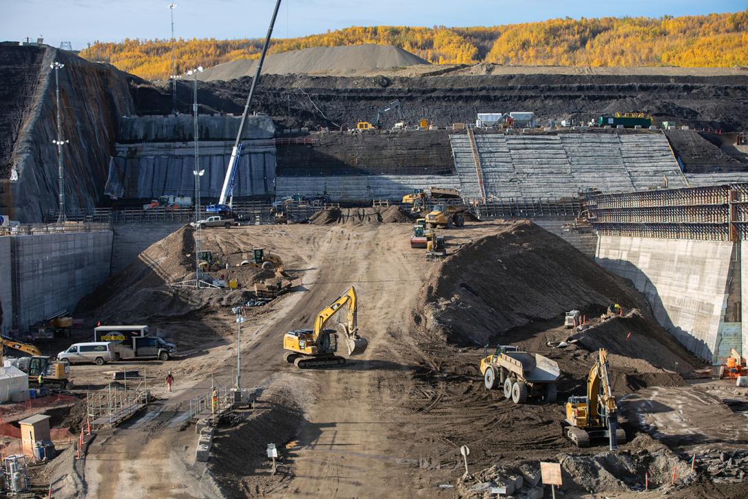 A ramp is constructed to provide access for trucks onto the spillway buttress to deposit roller-compacted concrete. | September 2019 