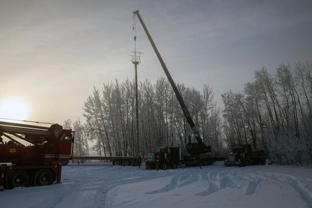 The 18-metre-long pole is hoisted into position and the base is encased in a concrete foundation. | November 2020