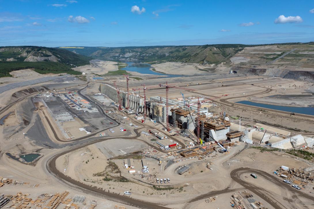 An upstream view over the approach channel, spillway upper headworks, intake gates, and roller compacted concrete buttress. | July 2022