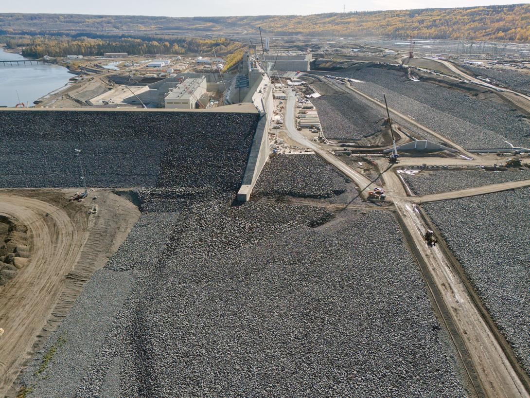 The approach channel is lined with several layers, including a final layer of rip rap. Water will flow down the approach channel, then pass through the intakes and into the powerhouse to generate electricity.